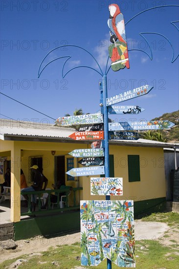 WEST INDIES, St Vincent & The Grenadines, Union Island, Signpost beside a rum shop in Clifton