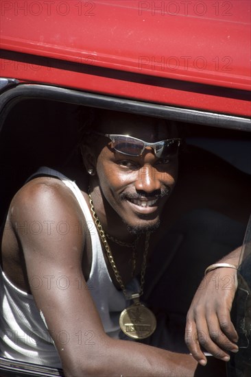 WEST INDIES, St Vincent & The Grenadines, Union Island, Young man in minibus wearing large golden medallion