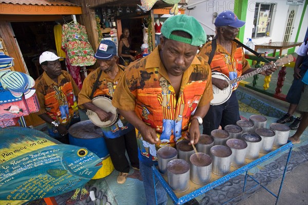 WEST INDIES, St Vincent & The Grenadines, Union Island, Miniature steel drum pan player and band playing at a roadside bar during Easterval Easter Carnival in Clifton