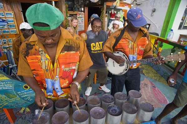 WEST INDIES, St Vincent & The Grenadines, Union Island, Miniature steel drum pan player and band playing at a roadside bar during Easterval Easter Carnival in Clifton