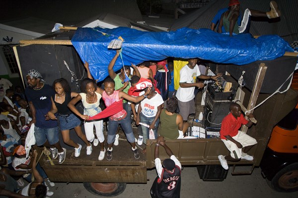 WEST INDIES, St Vincent & The Grenadines, Union Island, Mobile sound system and dancers on a truck at Easterval Easter Carnival procession around the island
