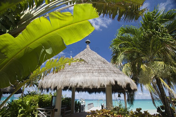 WEST INDIES, St Vincent & The Grenadines, Canouan, Palapa thatched entrance from hotel jetty at Tamarind Beach Hotel in Charles Bay