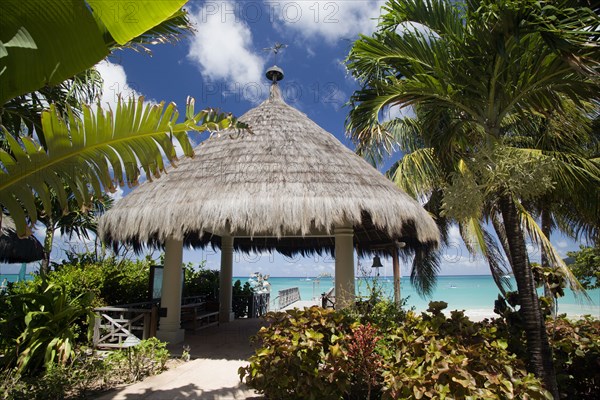 WEST INDIES, St Vincent & The Grenadines, Canouan, Palapa thatched entrance from hotel jetty at Tamarind Beach Hotel in Charles Bay