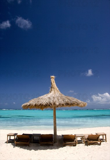 WEST INDIES, St Vincent & The Grenadines, Canouan, Palapa thatched shelter and sunbeds on Godahl Beach at Raffles Resort