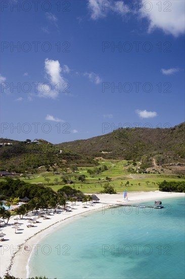 WEST INDIES, St Vincent & The Grenadines, Canouan, Jambu Beach in Carenage Bay at Raffles Resort with the Trump International Golf Course behind