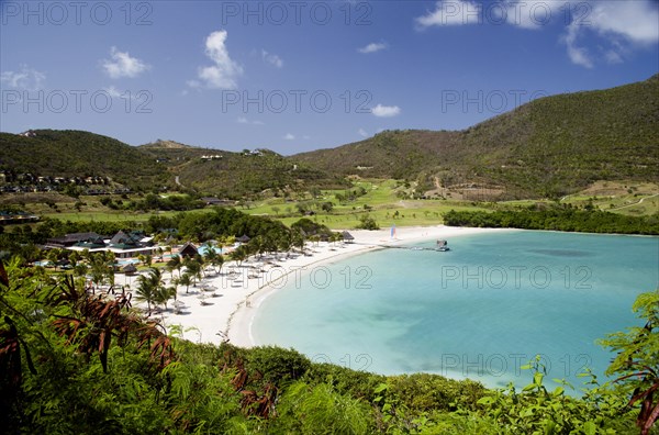 WEST INDIES, St Vincent & The Grenadines, Canouan, Jambu Beach in Carenage Bay at Raffles Resort with the Trump International Golf Course behind