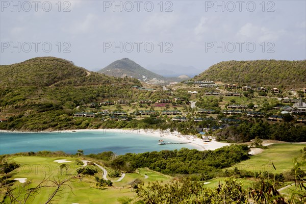 WEST INDIES, St Vincent & The Grenadines, Canouan, Jambu Beach at Raffles Resort and the Trump International Golf Course with Union Island in the distance