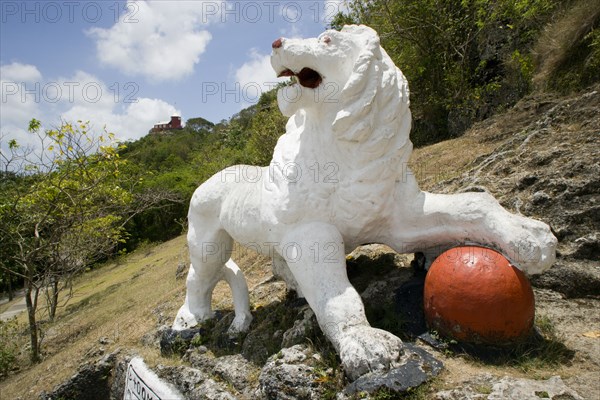 WEST INDIES, Barbados, St George, Imperial lion carved from coral rock by British soldiers serving at Gun Hill signal station with the station on the hill in the distance