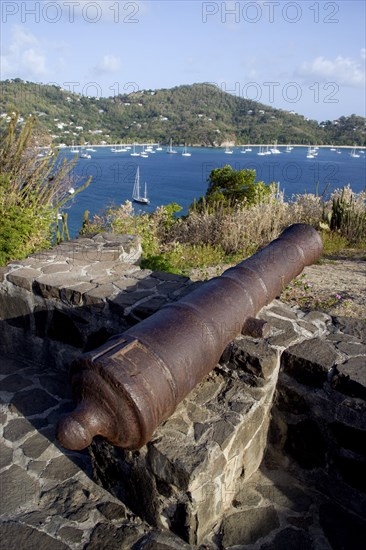 WEST INDIES, St Vincent & The Grenadines, Bequia, Canon on the 18th Century Hamilton Battery overlooking Admiralty Bay and moored yachts