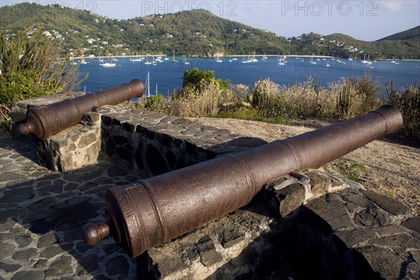 WEST INDIES, St Vincent & The Grenadines, Bequia, Canon on the 18th Century Hamilton Battery overlooking Admiralty Bay and moored yachts