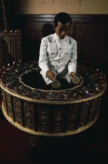 THAILAND, Bangkok, Musician playing Burmese circular drum at School of Music and Dance.