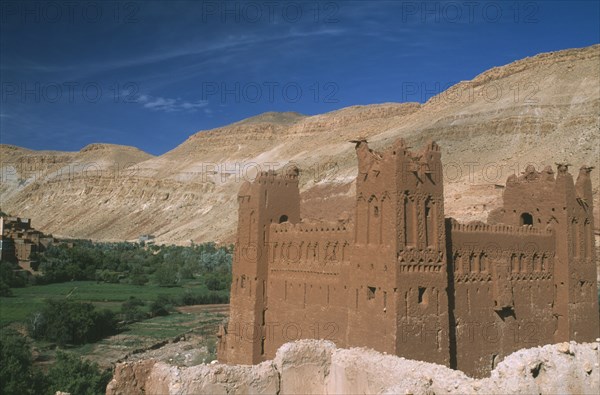 MOROCCO, High Atlas Mountains, Tioughassine, Kasbah overlooking fertile valley floor.