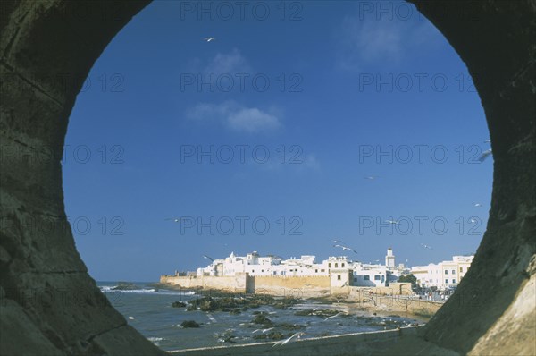 MOROCCO, Essaouira, Fortified coastal town framed in circular opening in wall.