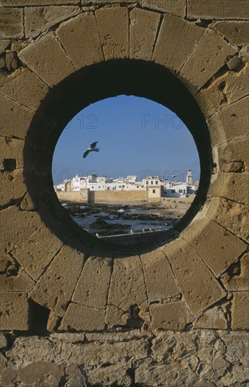 MOROCCO, Essaouira, Fortified coastal town framed in circular opening in wall.