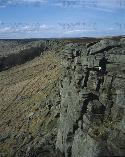 ENGLAND, Derbyshire, Stanage Edge, View northwards along edgeof gritstone craggs with rock climbers.