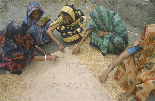 BANGLADESH, Khulna, Char Kukuri Mukuri, Women drawing a map of village as part of community development project.