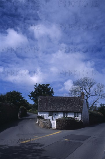 UNITED KINGDOM, Channel Islands, Guernsey, St Saviours. Small white cottage on corner of road junction.