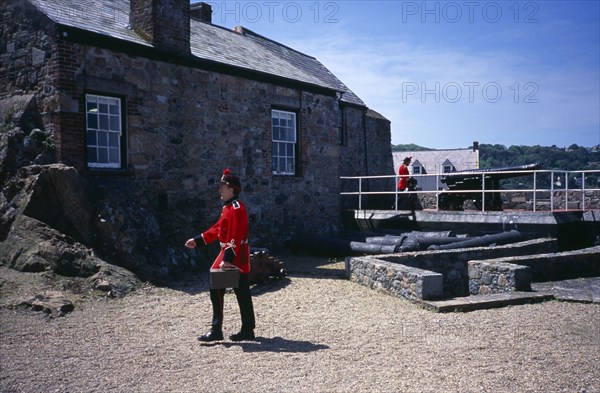 UNITED KINGDOM, Channel Islands, Guernsey, St Peter Port. Castle Cornet. Noon Day Guard walking in grounds.