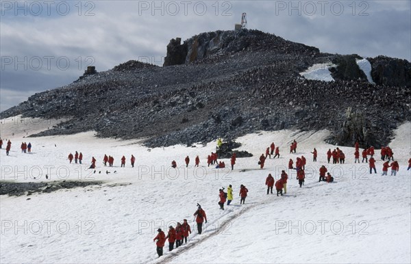 ANTARCTICA, South Shetland Is., Half Moon Island, Tourists at chinstrap penguin rookery.