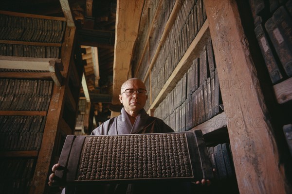 SOUTH KOREA, South Kyongsan, Mount Kaya, "Temple of Haeinsa.  Monk with one of the Tripitaka Koreana, the most complete collection of Buddhist texts engraved on 80,000 woodblocks 1237-1248"