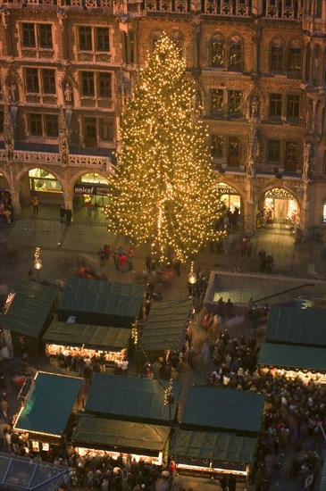 GERMANY, Bavaria, Munich, The Christmas tree and stalls in front of the Rathaus during the Christmas Market.