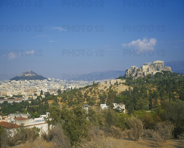 GREECE, Central, Athens, Acropolis and Lykavitos in the distance.View of the countryside with the town behind. More hills in the far distance.