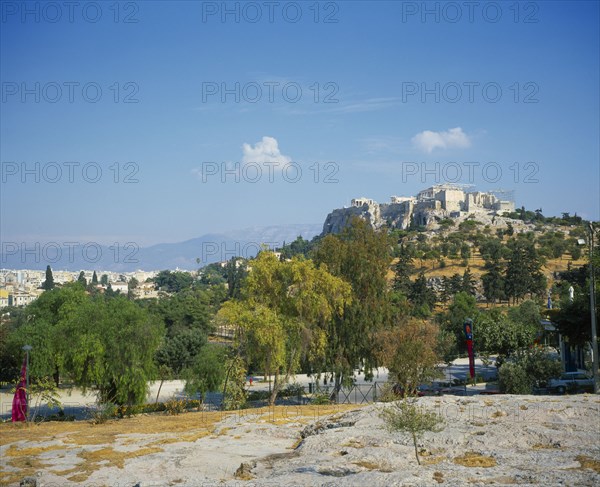 GREECE, Central, Athens, A road with trees either side in the foreground with the Acropolis up the hill.