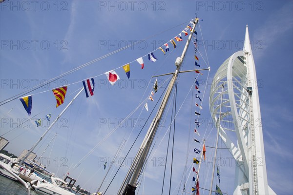 ENGLAND, Hampshire, Portsmouth, The Spinnaker Tower the tallest public viewing platforn in the UK at 170 metres on Gunwharf Quay with flag decorated yachts mast in the foreground