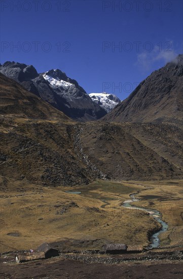 BOLIVIA, Cordillera Norte , Settlement with mountains behind with snow on the peaks.