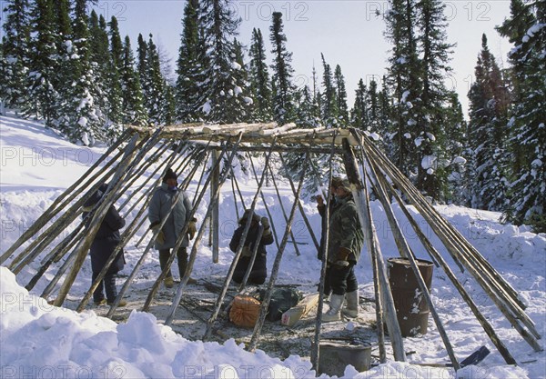 CANADA, Northern Quebec, "James Bay,", A group of people constructing a camp out of wood in the snow.
