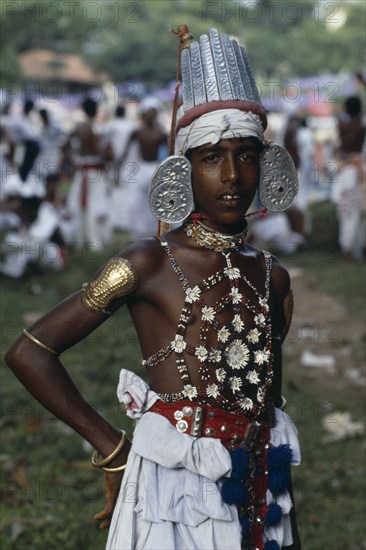 SRI LANKA, Kandy, Portrait of young man dressed for Kandy Esala Perahera.  Procession to honour sacred tooth ehshrined in the Dalada Maligawa Temple of the Tooth.