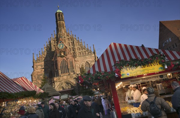 GERMANY, Bavaria, Nuremberg, The Christmas Market in Hauptmarkt with The Frauenkirche behind.