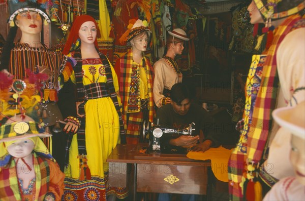 BOLIVIA, La Paz, Costume maker for Oruro Carnival. Man working on sewing machine.