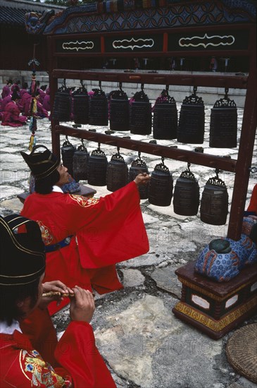 SOUTH KOREA, Seoul, Confucian Rites Ceremony at Chong Shrine. Men in red robes sat on ground sounding chimes