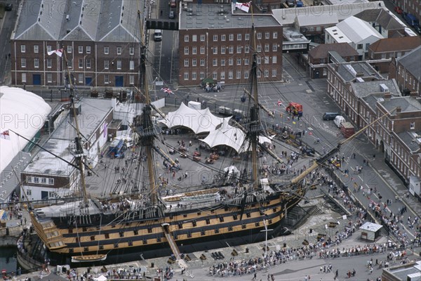 ENGLAND, Hampshire, Portsmouth, HMS Victory. Arial view of Royal Naval Dockyard. People crowding round.