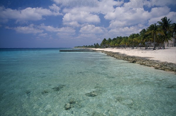 CUBA, Pinar del Rio, Maria la Gorda, "Narrow stretch of empty sandy beach fringed with palm trees beside clear, sparkling water."