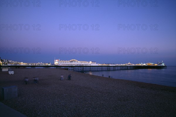 ENGLAND, East Sussex, Brighton, Brighton Pier illuminated in evening light.