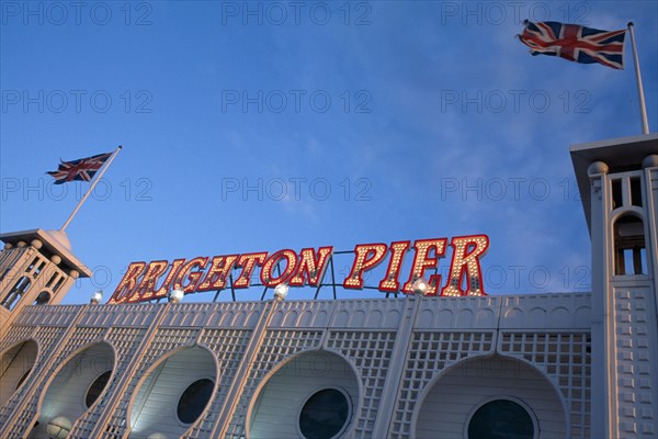 ENGLAND, East Sussex, Brighton, Brighton Pier. Detail of neon sign with Union Jack flags flying either side.