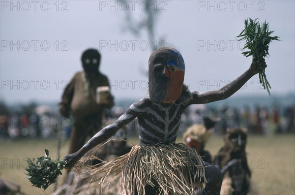 CONGO, Gungu, Bapende tribe masked dancer wearing grass skirt and body paint at Gungu Festival.