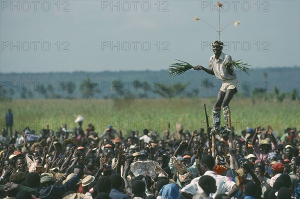 CONGO, Gungu, Stilt walker above crowds at Bapende tribe Gungu Festival.
