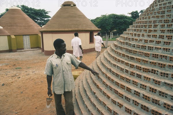 ANGOLA, Tradtional Homes, Builder working on new village housing.