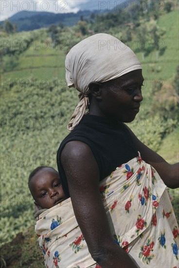 GHANA, Children, Carrying, Traditional Ghanaian way of holding baby in printed cotton sling on back.