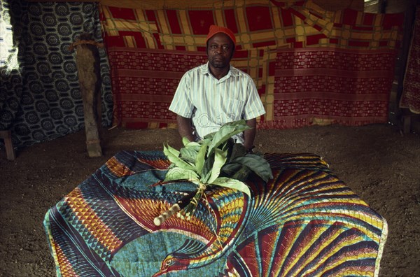 CAMEROON, South West, Rumpi Hills, Leopard Cult elder sitting inside Ekpe house with spiritually charged leaves.