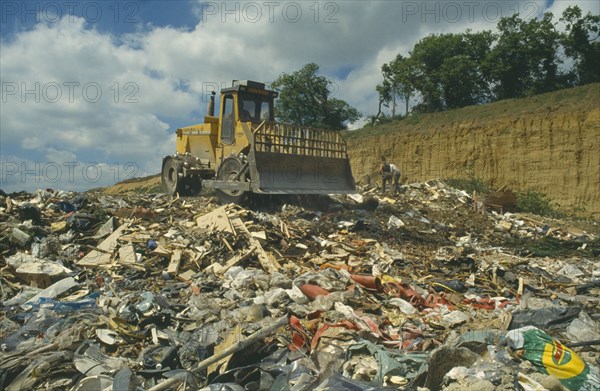ENGLAND, Surrey, Environment, Bulldozer on heap of rubbish in landfill site.