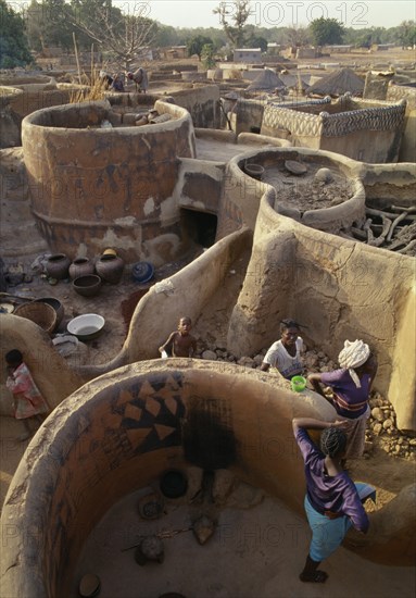 BURKINA  FASO, Tiebele, View above traditional Gourounsi village with people amongst buildings.