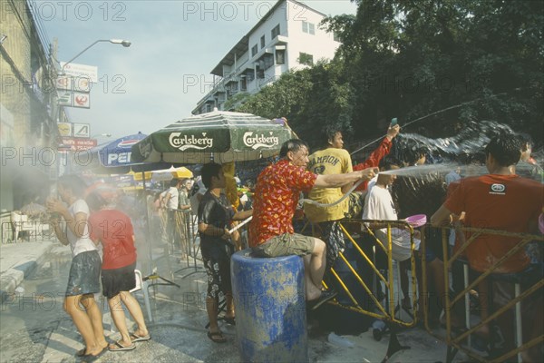 THAILAND, Bangkok, "Crowd having a water fight, celebrating the Songkhran Festival. Thai New Year, 15 April."