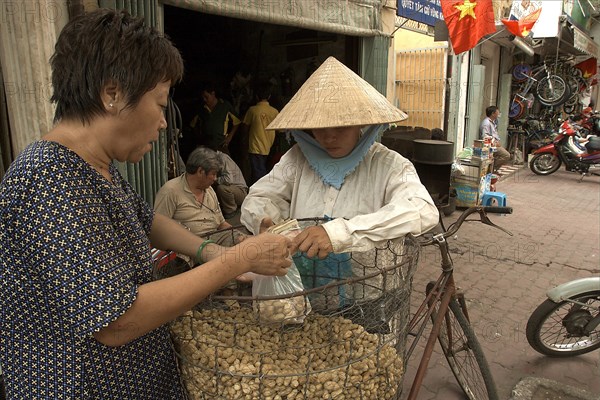 VIETNAM, South, Ho Chi Minh City, A woman selling peanuts from her bicycle