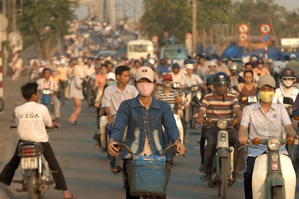 VIETNAM, South, Ho Chi Minh City, Busy street with people riding motorbikes and bicycles