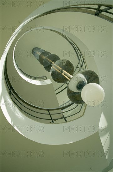 ENGLAND, East Sussex, Bexhill on Sea, De La Warr Pavilion. Interior view looking upwards at the helix like spiral staircase and Bauhaus globe lamps.