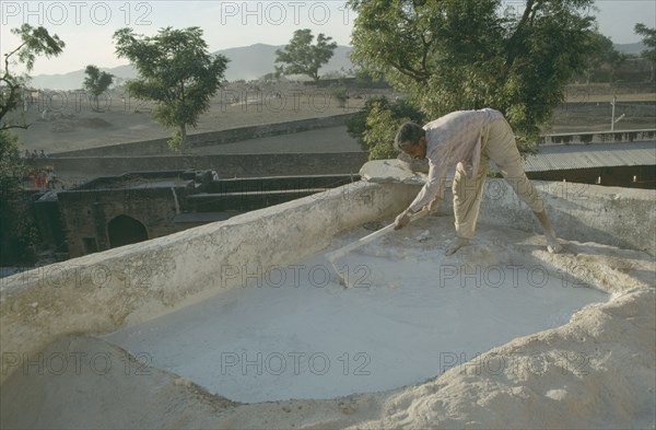 INDIA, Rajasthan, Man mending the roof of his house.